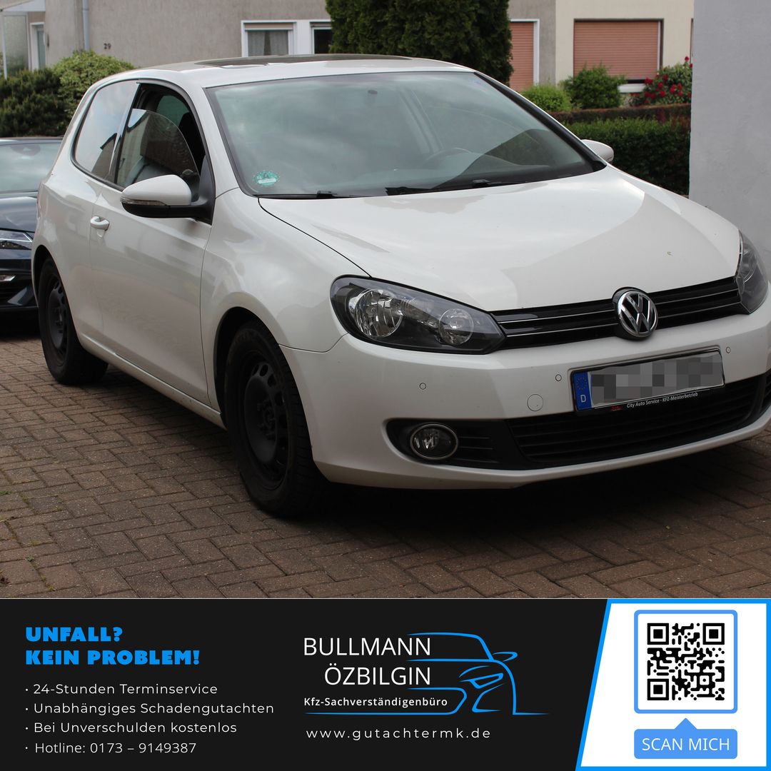 Weißer Volkswagen Kleinwagen, Front- und Seitenansicht, geparkt auf gepflastertem Untergrund vor Wohngebäuden.