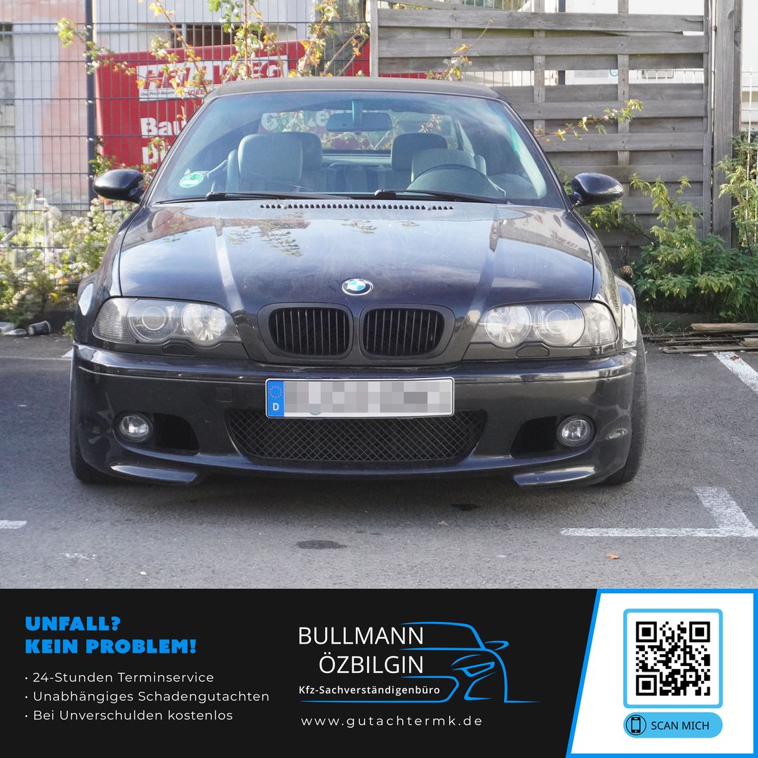 Schwarzer BMW mit deutschem Kennzeichen, frontal geparkt vor Holzzaun und Büschen.