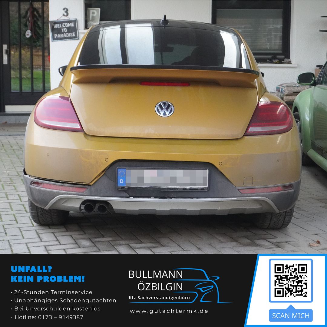 Heckansicht eines goldfarbenen Volkswagen Beetle mit Spoiler, geparkt vor einem Haus mit Fenster und Tür.