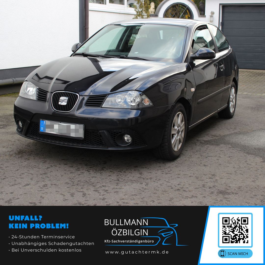 Schwarzer Seat-Kleinwagen steht vor einem weißen Haus mit Garage, Vorderansicht leicht schräg von links.