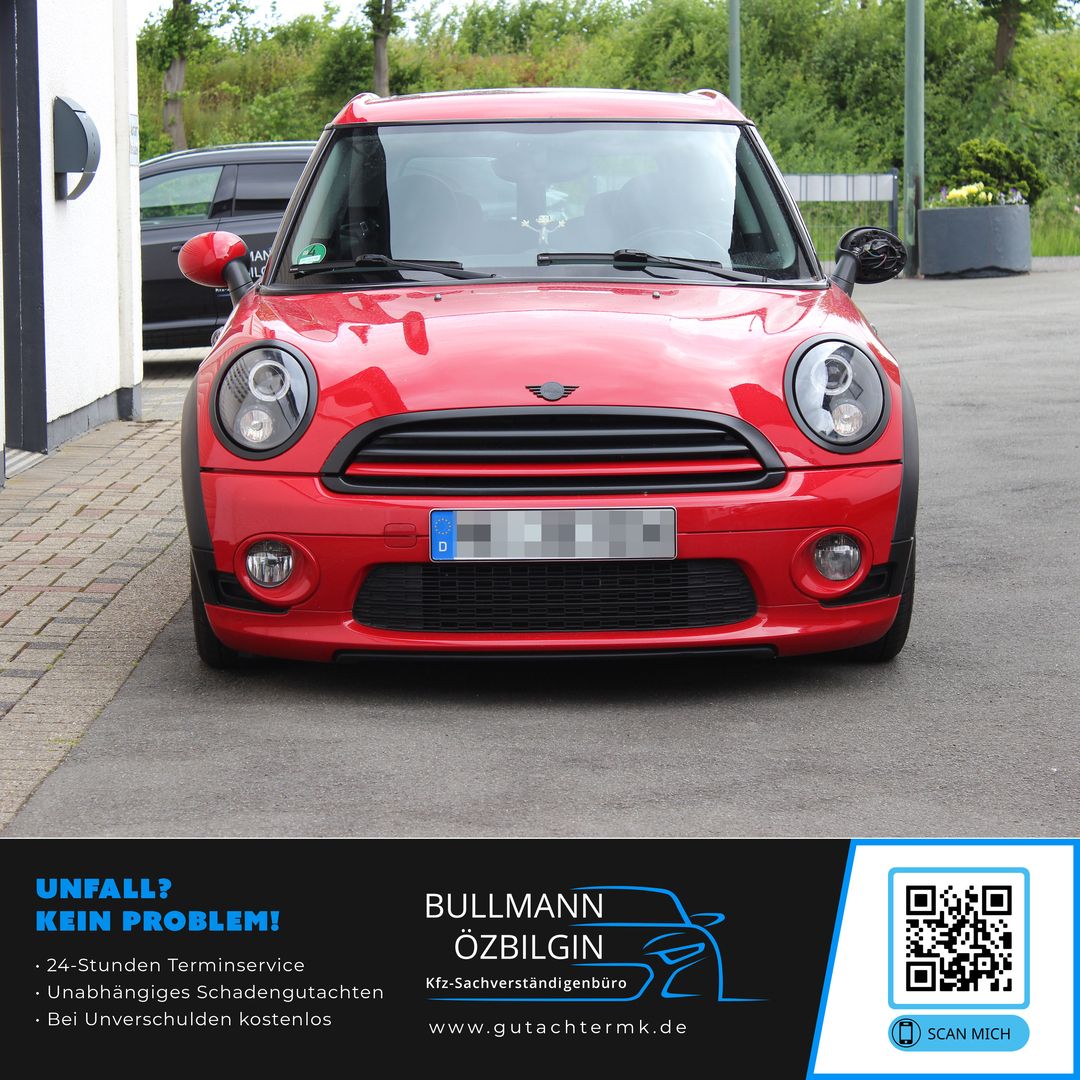 Rote Mini Cooper Frontansicht auf einer Straße, links und rechts Außenspiegel sichtbar, Kennzeichen unkenntlich gemacht.