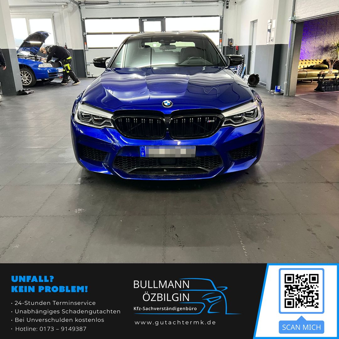 Frontansicht eines blauen BMW M5 F90 in einer Werkstatt zur Schadensaufnahme nach einem Vorfahrtunfall