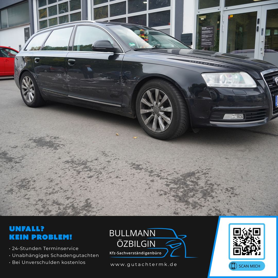 Schwarzer Kombi-Pkw mit abgeflachter Vorderachse vor einem Gebäude mit Glasfenstern und Türen.