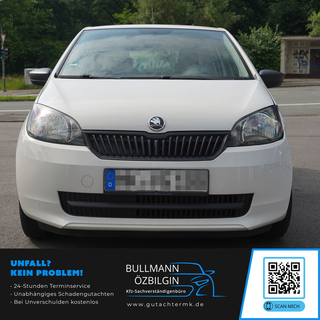 Vorderansicht eines weißen Škoda-Autos, das auf der Straße geparkt ist, mit einem Werbebanner für einen Fahrzeuginspektionsdienst am unteren Rand.