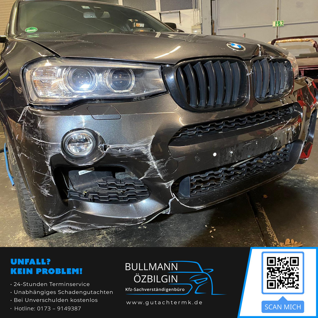 Frontalansicht eines grauen BMW X4 F26 mit massiven Unfallschäden an Stoßfänger und Scheinwerfer für ein KFZ-Gutachten